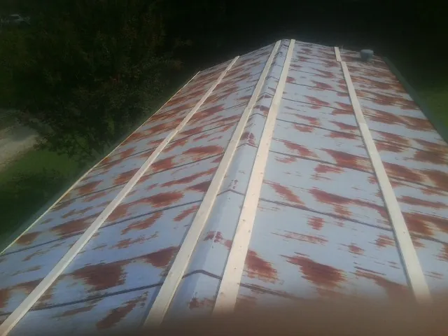 Rusted metal roof panels with new wood purlins before replacement — Storm Damage Roof Repair in Owings Mills by Roofing Brothers