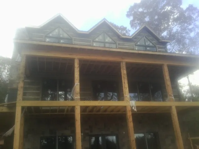 Dormers and porch framing on a large log home under construction — Roof Coating work by our crew in Owings Mills