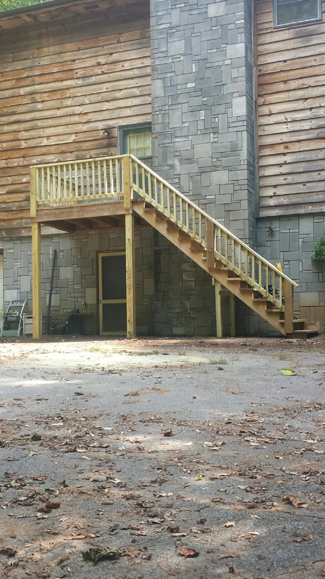 New pressure treated deck and stair landing on a log home in Owings Mills