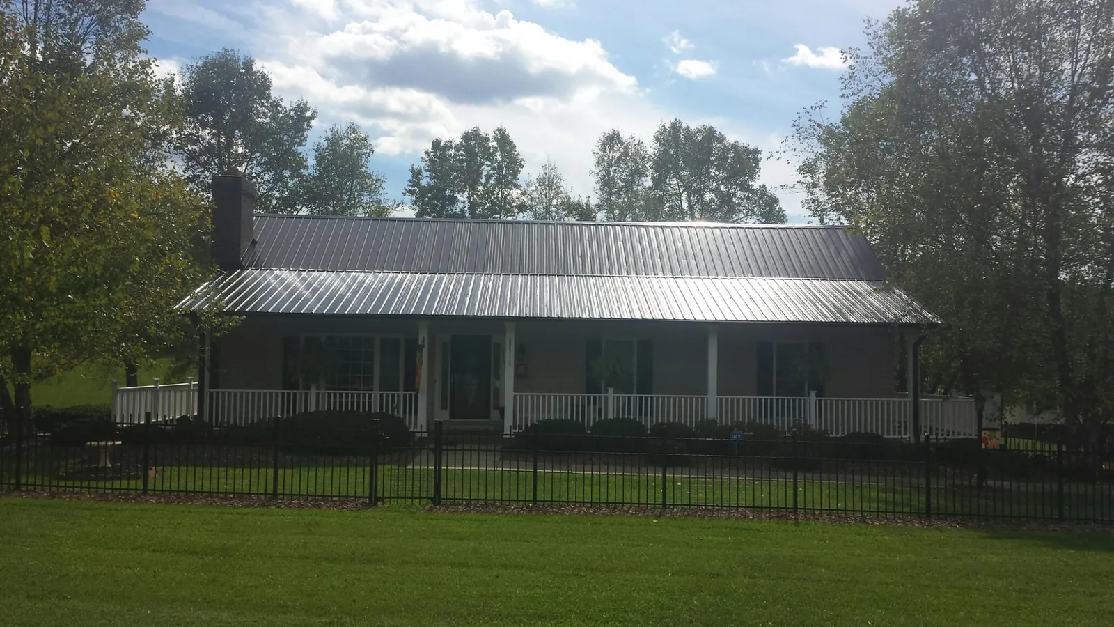 Gray metal roof on a brick ranch with a full width front porch — Gutter Guard Installation work by our crew in Owings Mills
