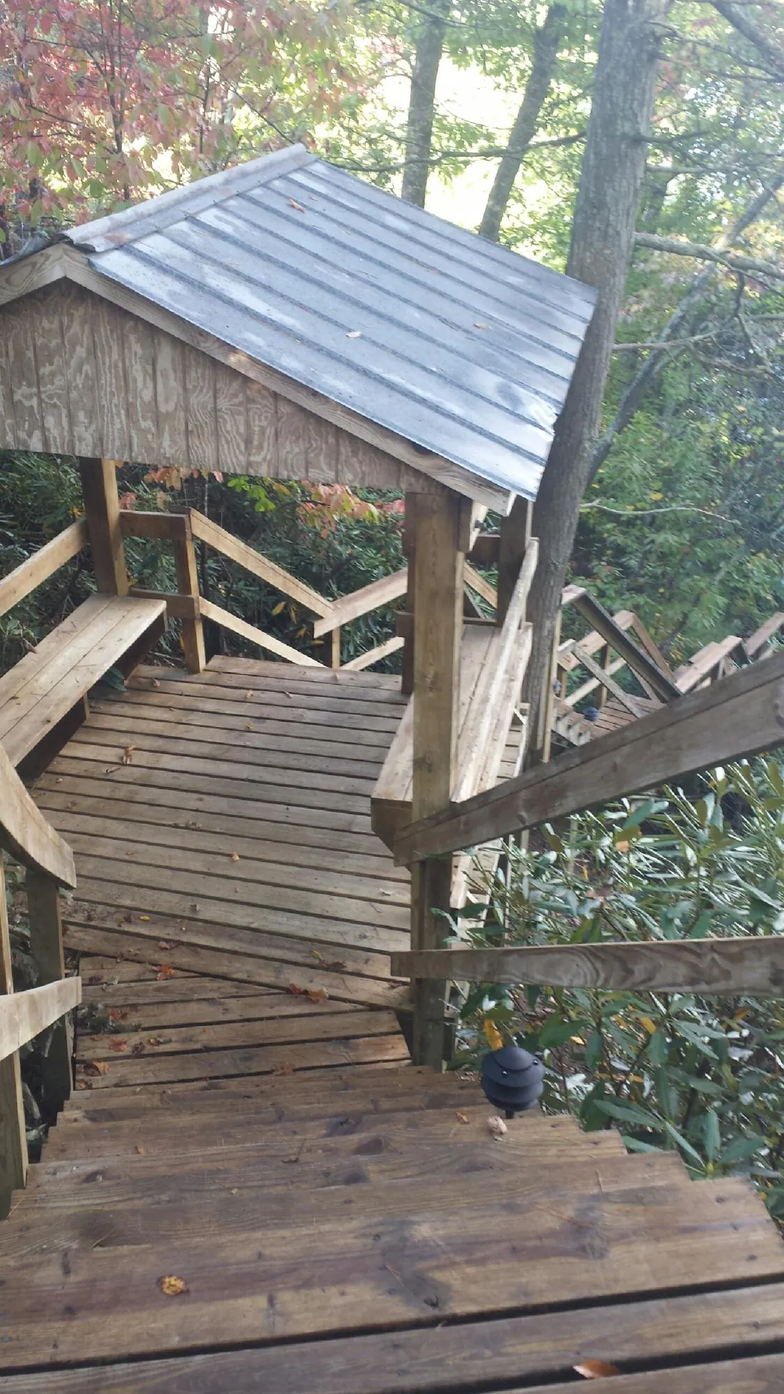 Metal roofed shelter over wooden steps on a wooded walkway — Skylight Repair & Installation work by our crew in Owings Mills