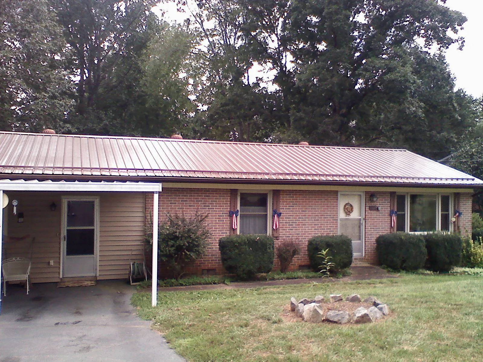 Bronze metal roof and carport on a brick ranch home — Roof Repair work by our crew in Owings Mills