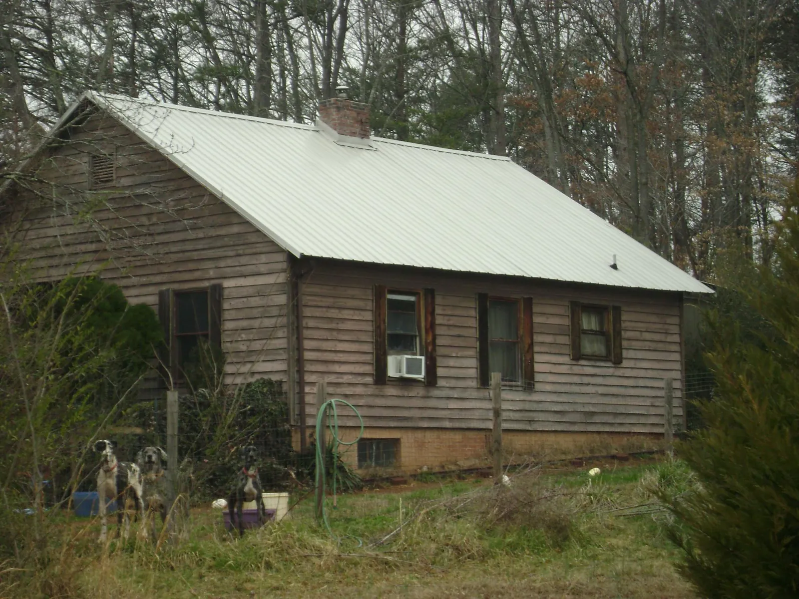 White metal roof on an old wood sided farmhouse, from a Asphalt Shingle Roof Repair job in Owings Mills
